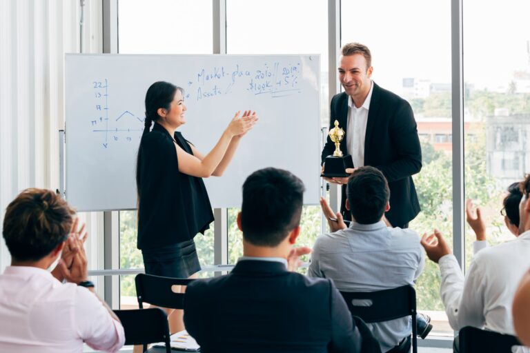 Boss awarding workers during conference